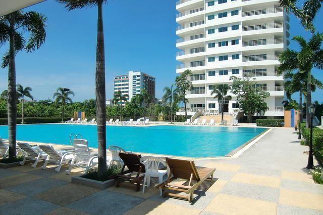 Condominium for sale in Jomtien showing the swimming pool and the condo building Condominium for sale in Jomtien showing the swimming pool and the condo building